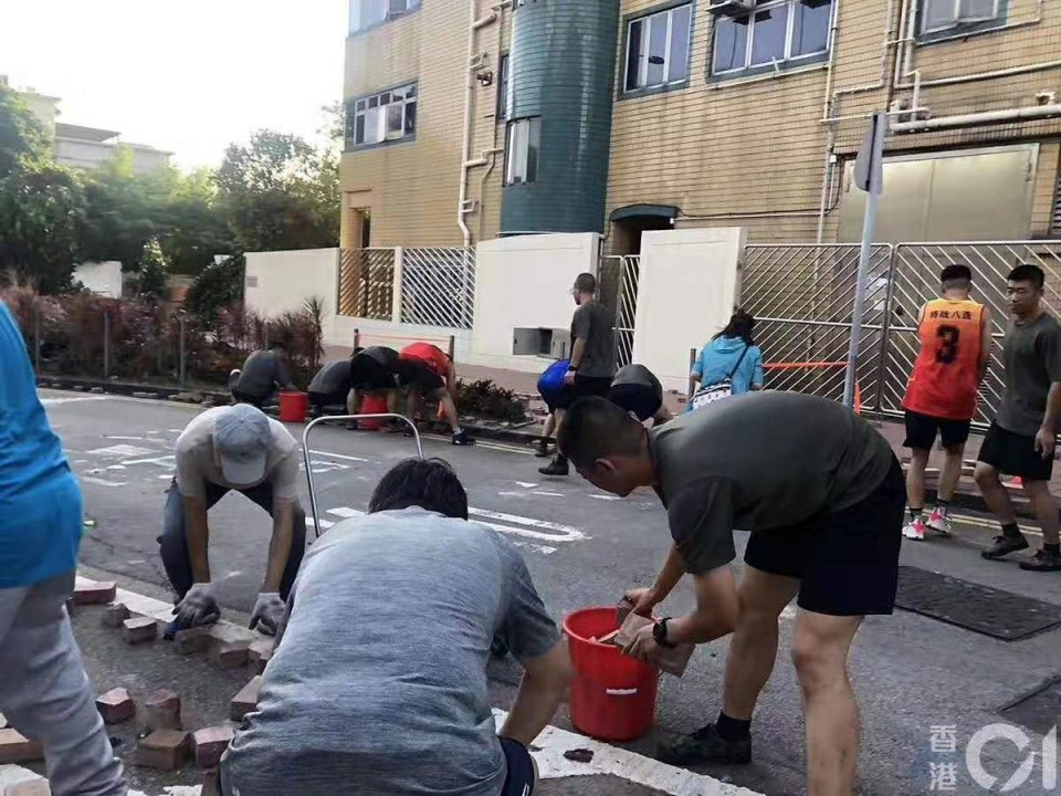 除了暖心的市民，香港民安队也加入到了清障的行列。15日下午，也有部分民安队队员在中环德辅道中协助清理砖块。（海外网 姚凯红）