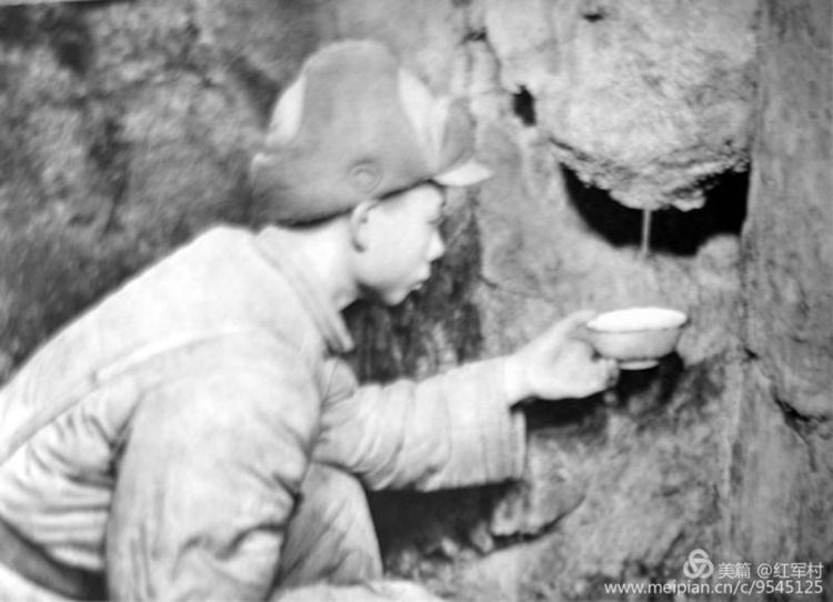 1952年冬志愿军战士用碗接住坑道岩石滴下来的水喝