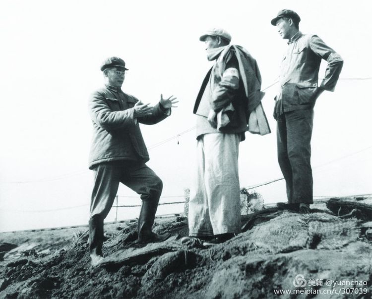 1956年和1957年，哈尔滨连续两年遭遇百年不遇的特大洪水，哈军工成为抗洪的主力军。图为刘居英在江堤上同水利专家研究抗洪方案。