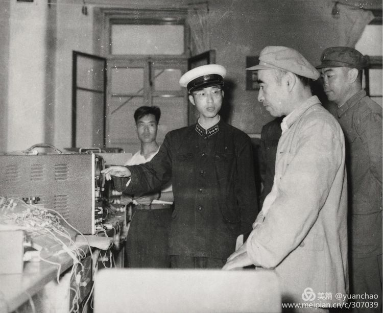 1961 年 8 月 7 日，林彪元帅（右二）视察哈军工，在刘居英（右一）陪同下参观海军工程系的电子计算机，听取柳克俊（左一）讲师的汇报。