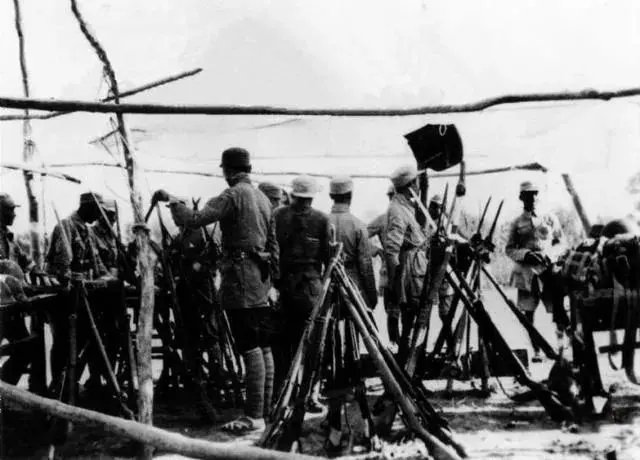 八路军指战员向观摩团展示缴获日军的武器。