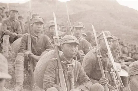 南泥湾的八路军战士们，他们即使是坐着，看起来仍然军容齐整，把枪支靠在肩膀上面，看上去真是一支能打硬仗的队伍。