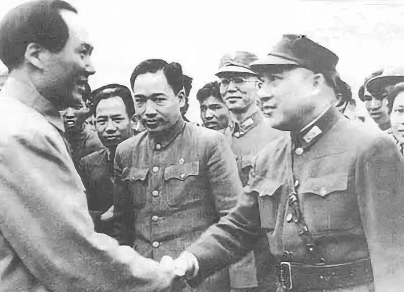 毛泽东与到机场迎接的蒋介石代表周至柔握手。