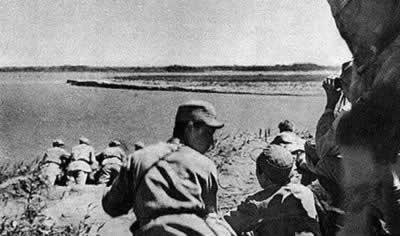 解放军指挥员在江边观察敌情，制订战斗方案