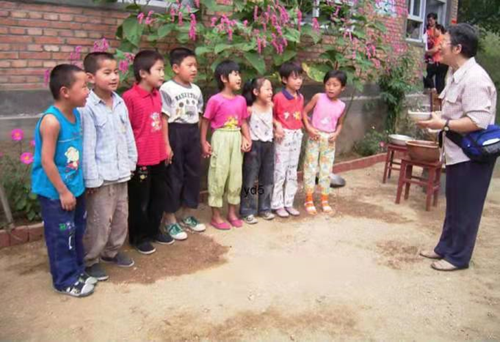 图5. 2005年邓小岚教马兰的孩子唱歌。