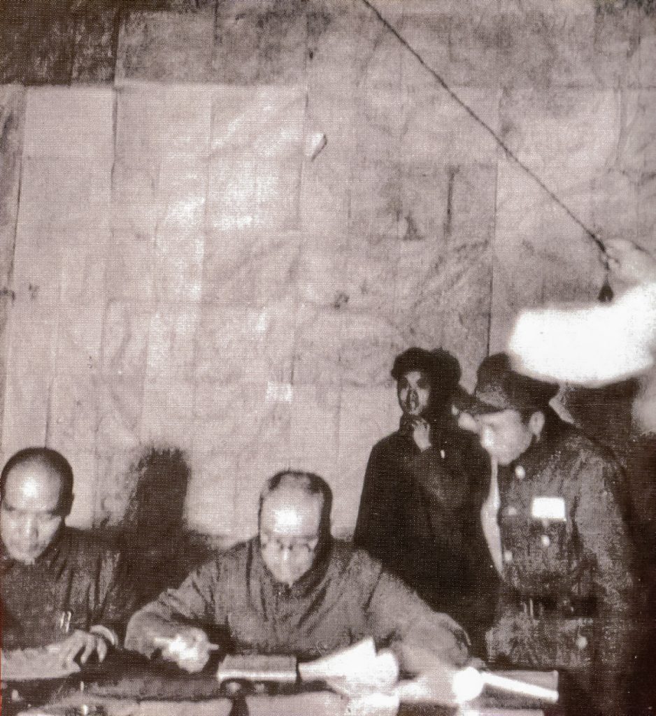 刘伯承司令员(左二)与李达参谋长(左一)在批阅前线部队的请示报告。