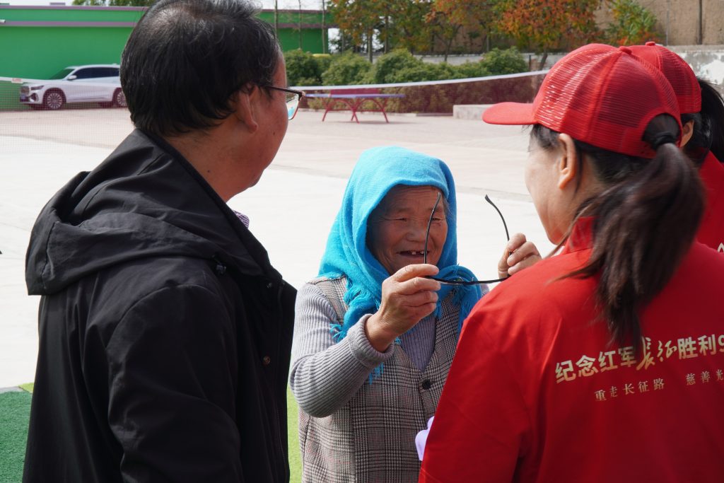 ③甘肃省会宁市新塬镇刘家湾村村民拿到主办方捐赠的老花镜后，开心地笑了。李易真 摄